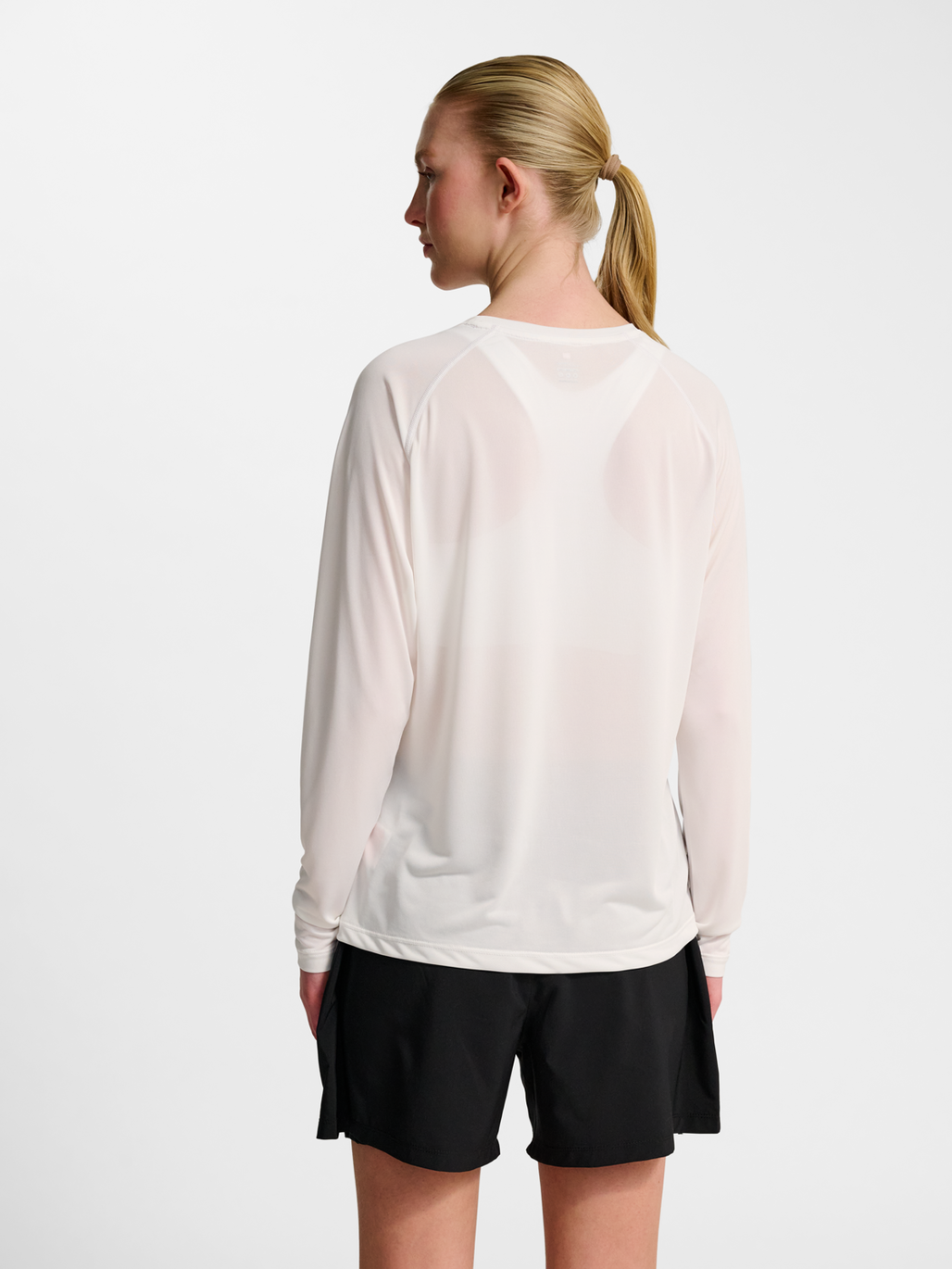 Women's white long-sleeve running shirt, side view on model