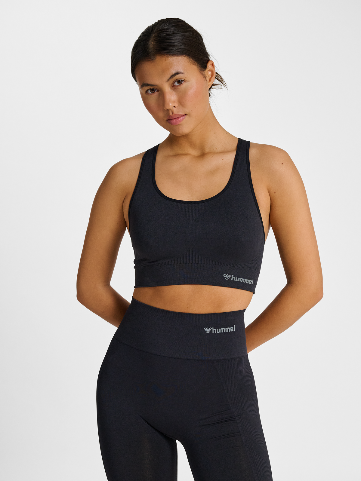 Women's black seamless sports top, front view on model