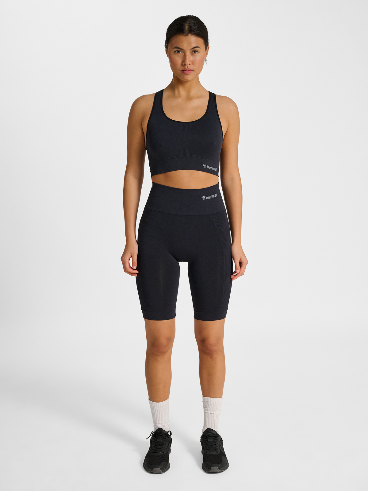 Women's black seamless sports top, side view on model