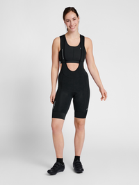 Women's black cycling bib shorts, back view on model
