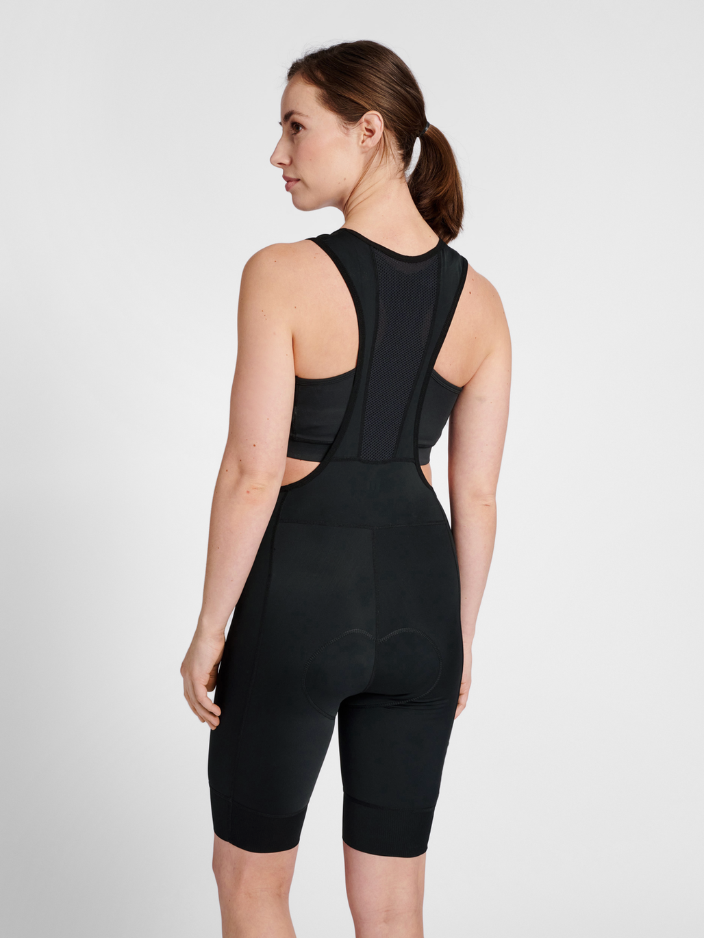 Women's black cycling bib shorts, side view on model