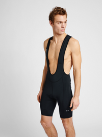 Men's cycling bib shorts in black, front view on model