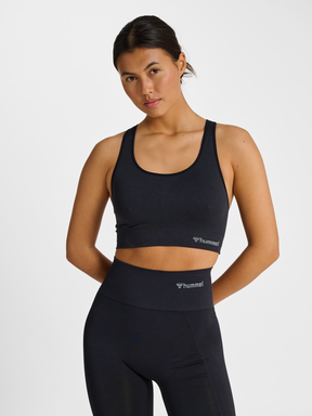 Women's black seamless sports top, front view on model