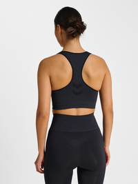 Women's black seamless sports top, back view on model