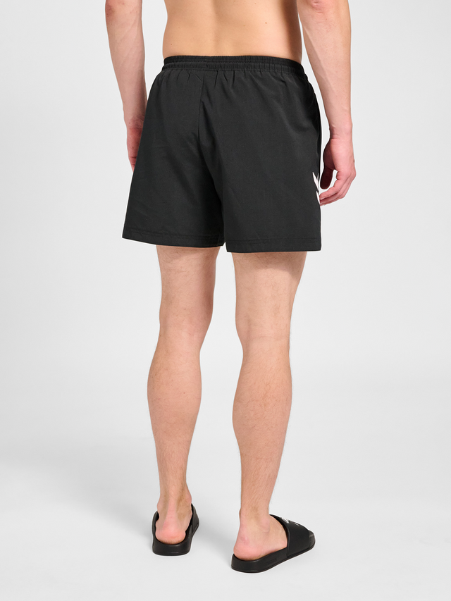 Men's black swim shorts, back view on model