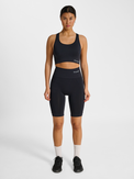 Women's black seamless sports top, side view on model