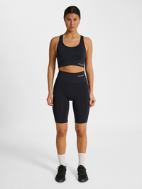 Women's black seamless sports top, side view on model